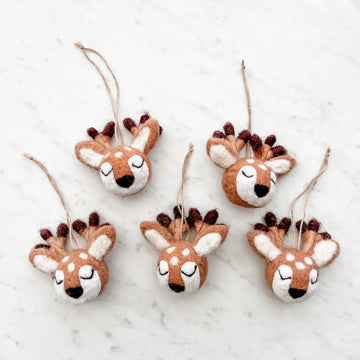 A set of five brown and white felt reindeer ornaments with black antlers, attached with strings for hanging.