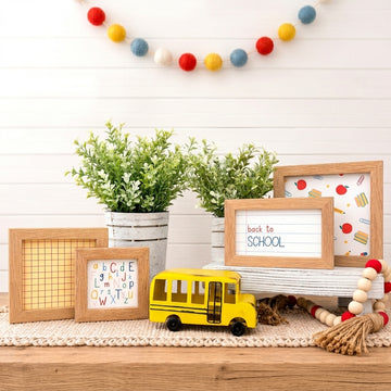 Set of 4 natural wood frames with back to school inserts inside of them, along with a metal school bus and decorative plants and beads.