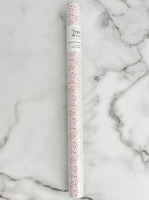 roll of white wrapping paper with gold on it