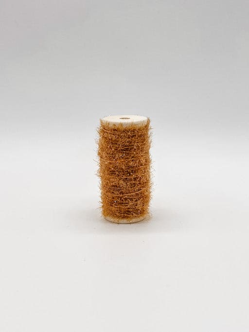 A collection of spools of tinsel in various colors scattered around, with wooden spool caps visible.