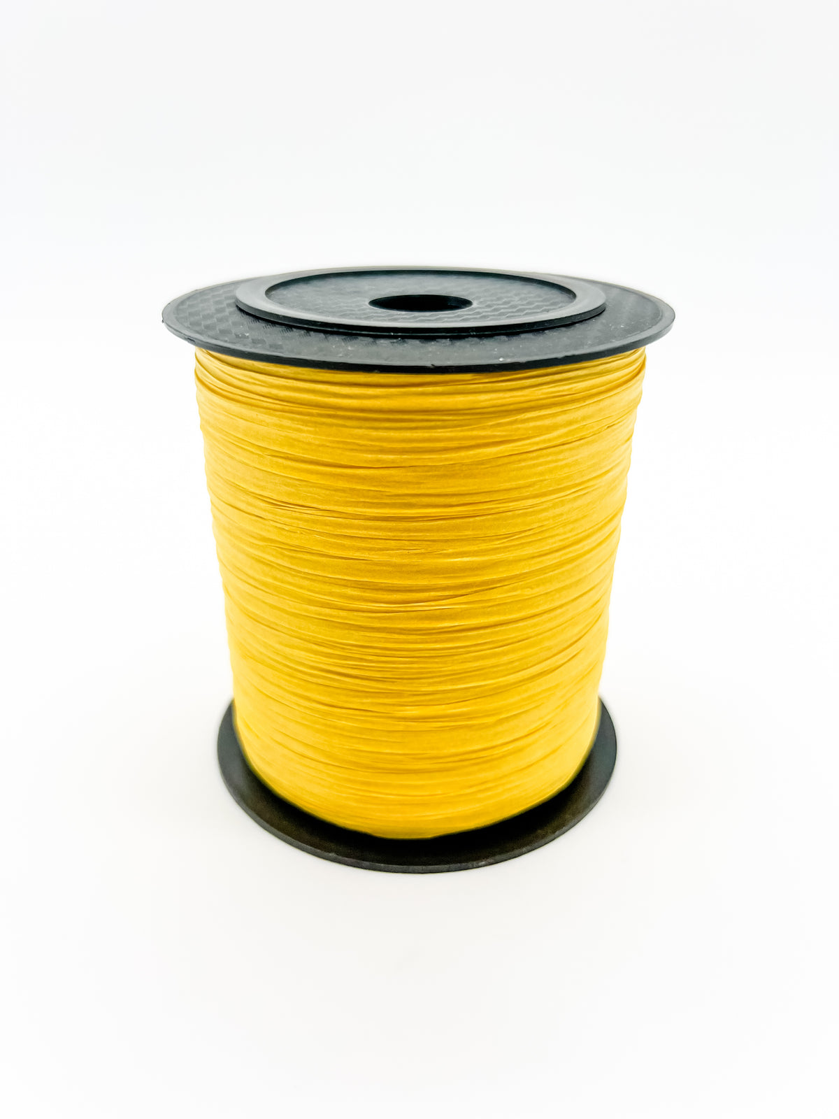 A spool of bright yellow paper raffia with a black plastic top and base, photographed on a clean white background.
