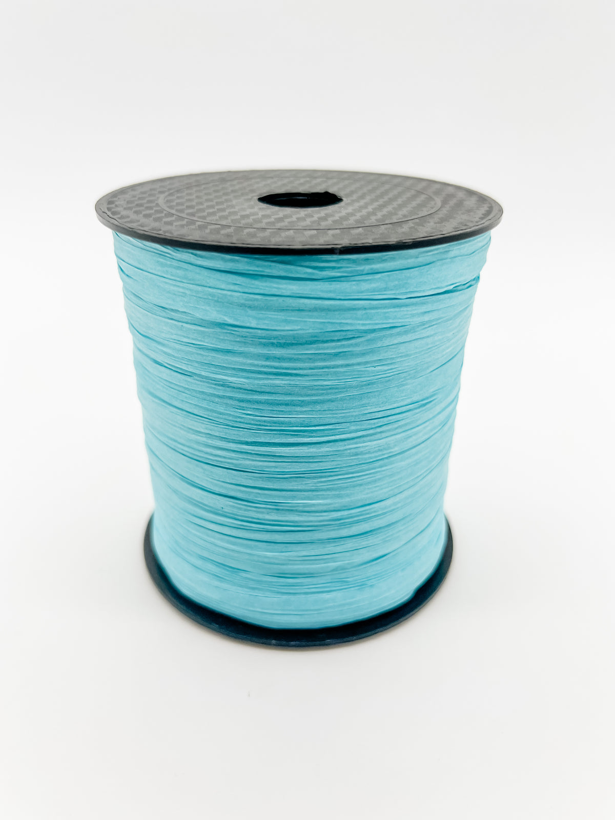 A spool of ocean blue paper raffia with a black plastic top and base, photographed on a clean white background.