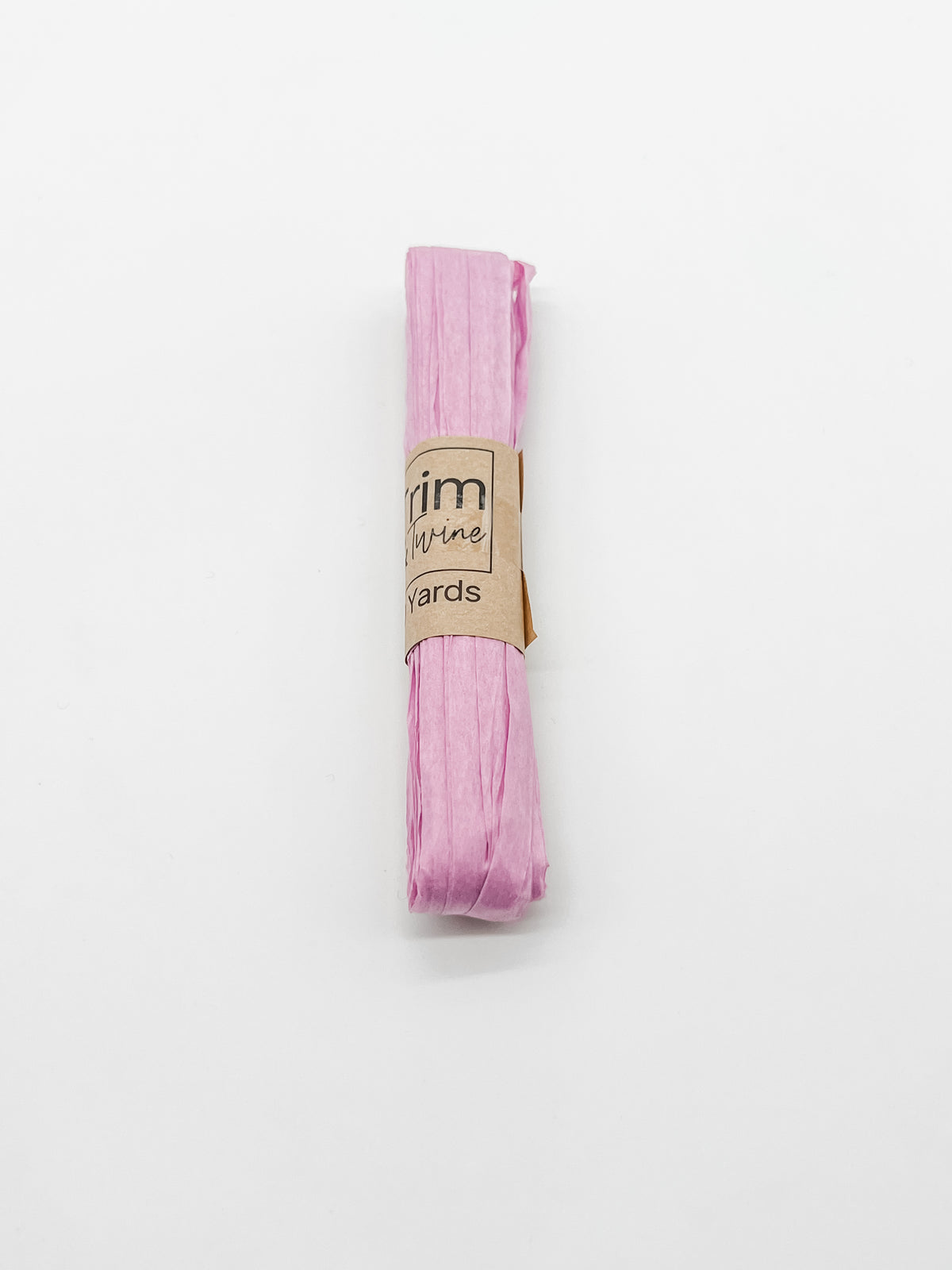 A roll of lilac raffia wrapped with a brown paper band that reads 'Trim & Twine' and '10 Yards', photographed on a plain white background.