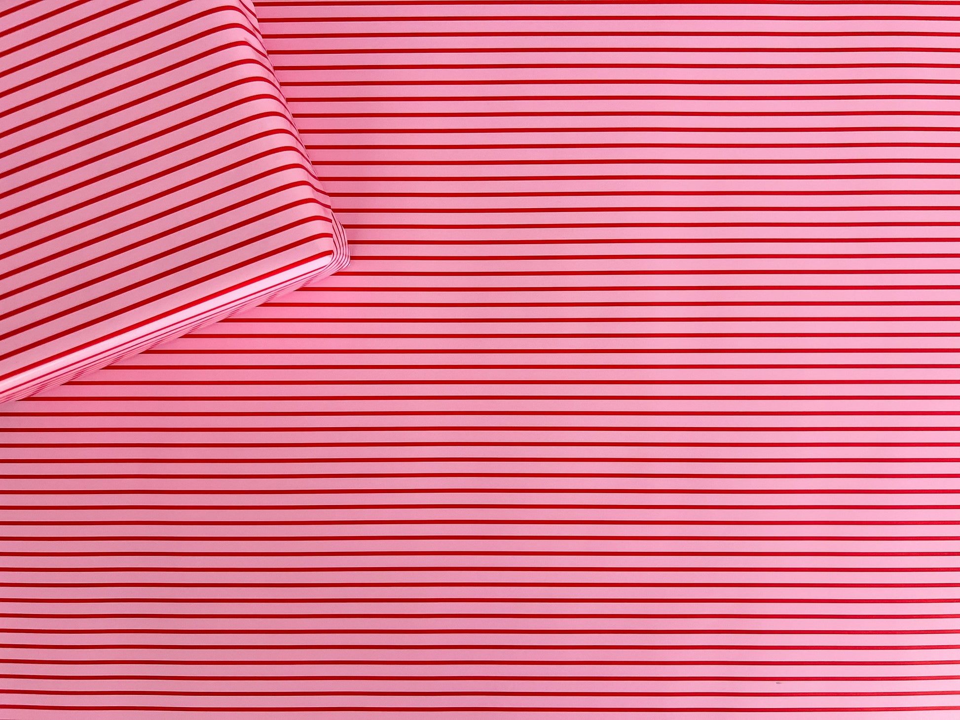 Close-up of pink wrapping paper with thin red stripes