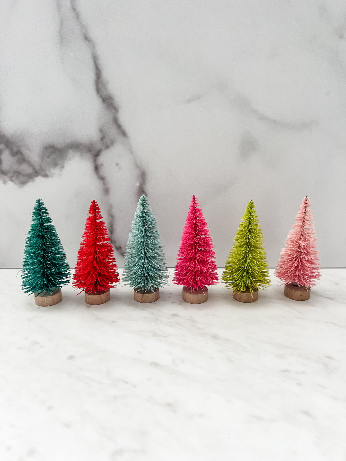 Set of 6 colorful bottle brush trees shown lined up