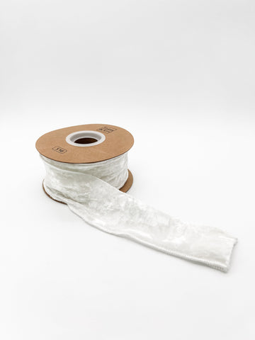 Spool of white velvet crushed ribbon on a white background