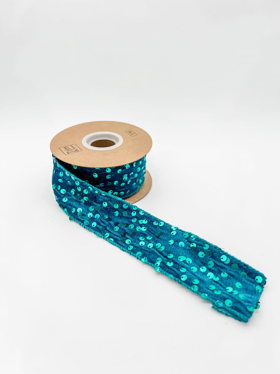 Spool of blue sequin ribbon on a white background