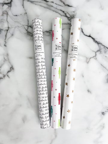 Three rolls of decorative paper with different designs on a marble surface