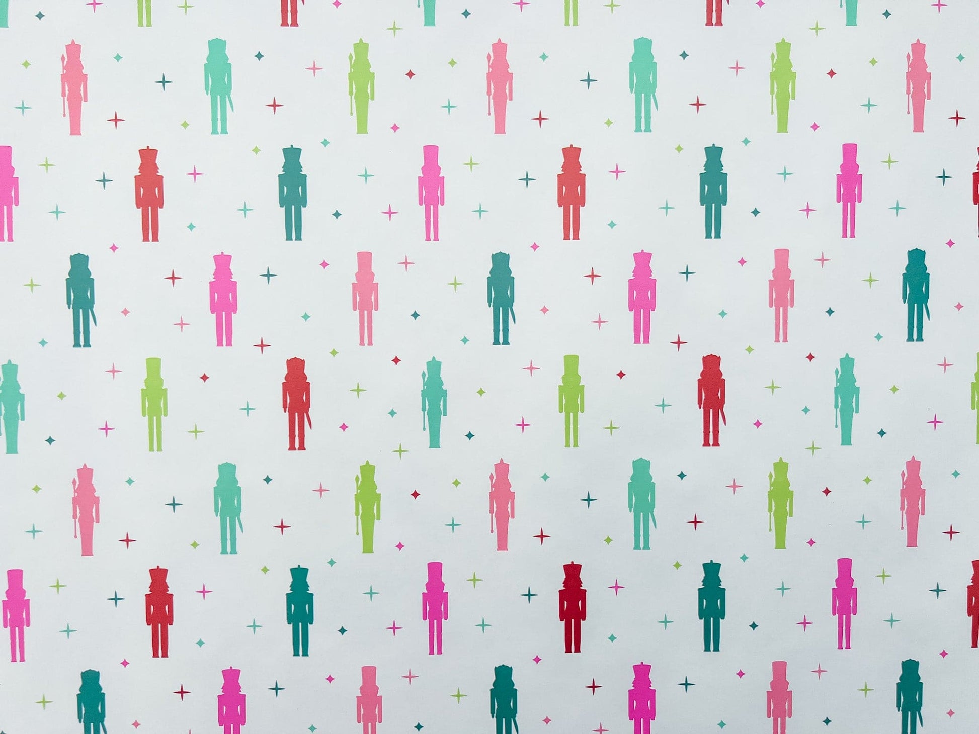 A laid out roll of wrapping paper with a colorful nutcracker pattern featuring nutcracker figures.