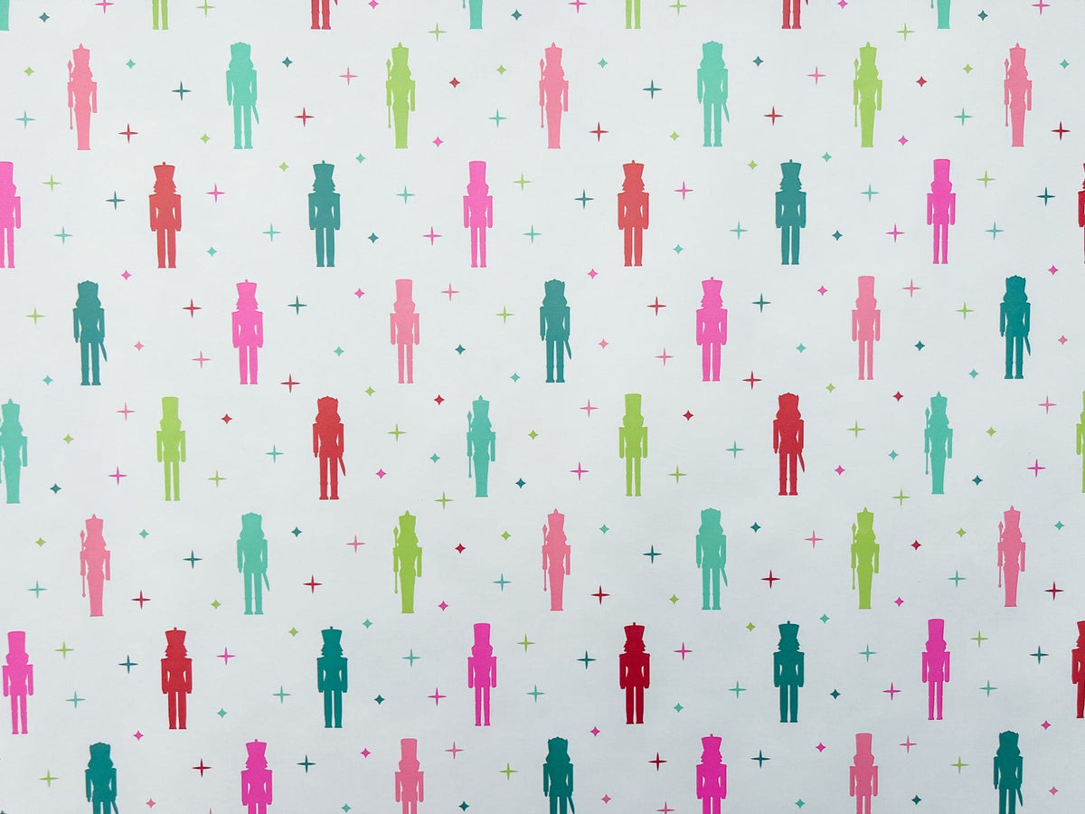 A laid out roll of wrapping paper with a colorful nutcracker pattern featuring nutcracker figures.