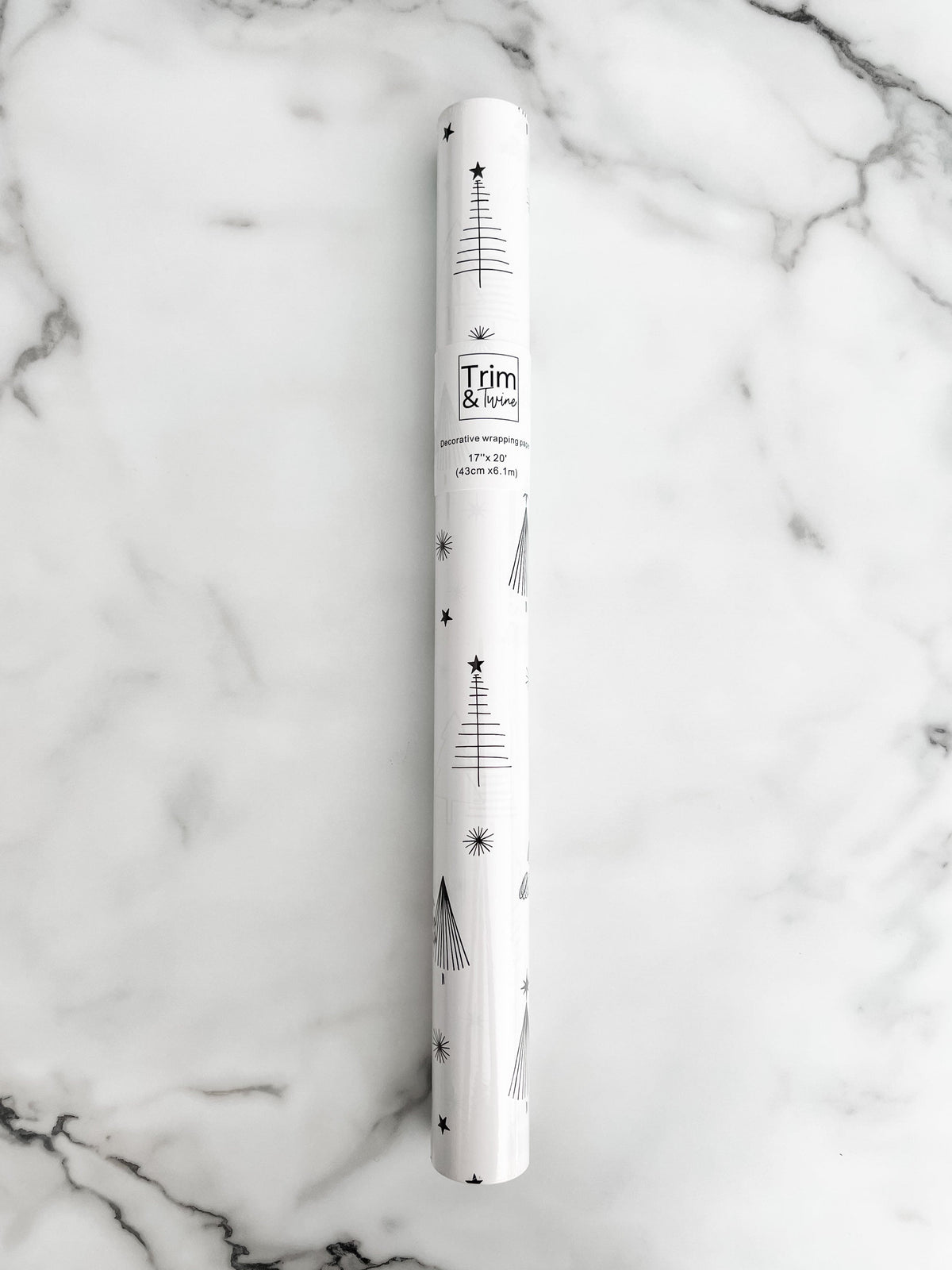 Roll of white wrapping paper with black and white trees and stars