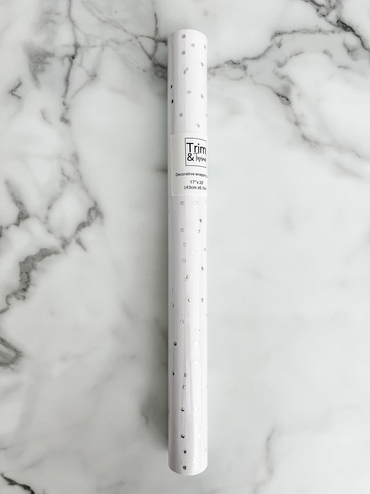 Roll of silver metallic dot paper on a white background.