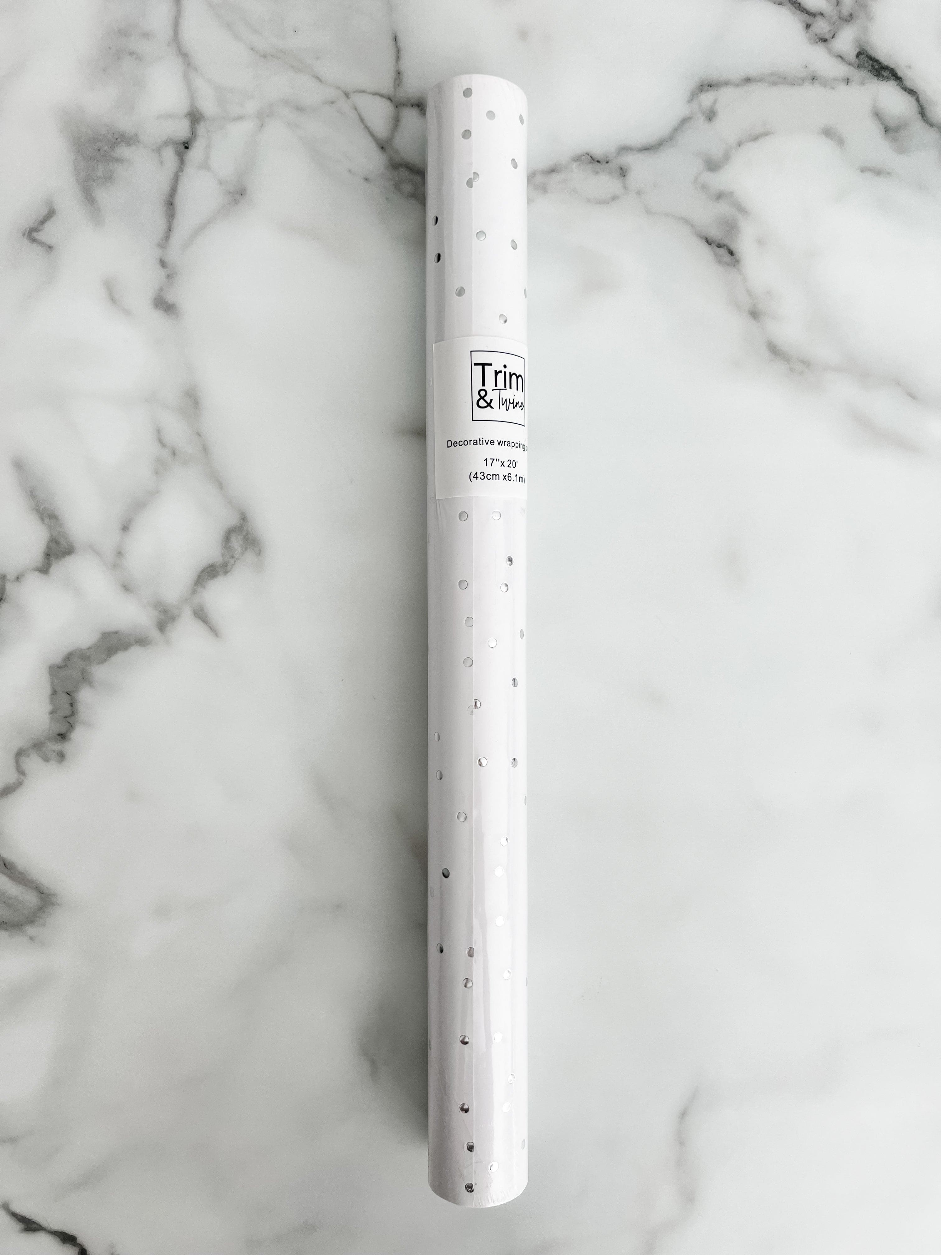 Roll of silver metallic dot paper on a white background.