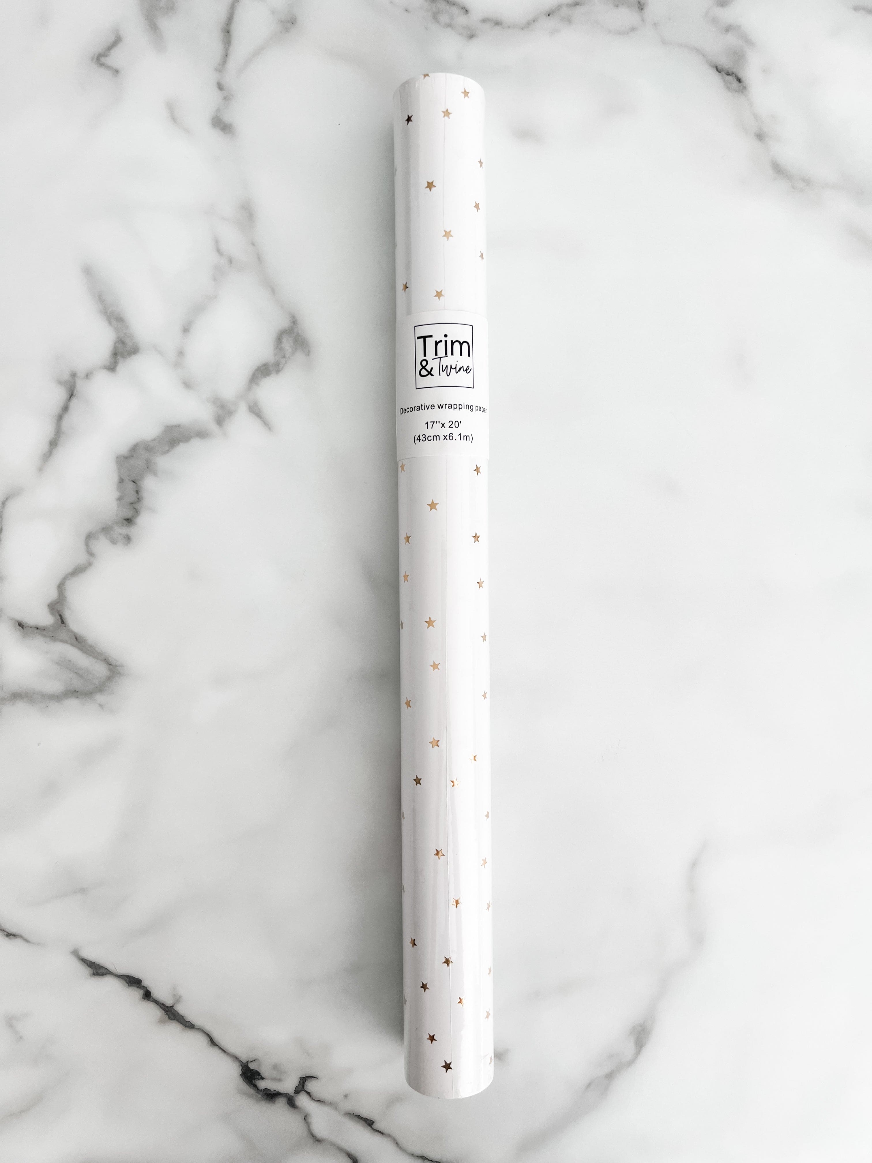 Roll of white paper with gold metallic stars on it