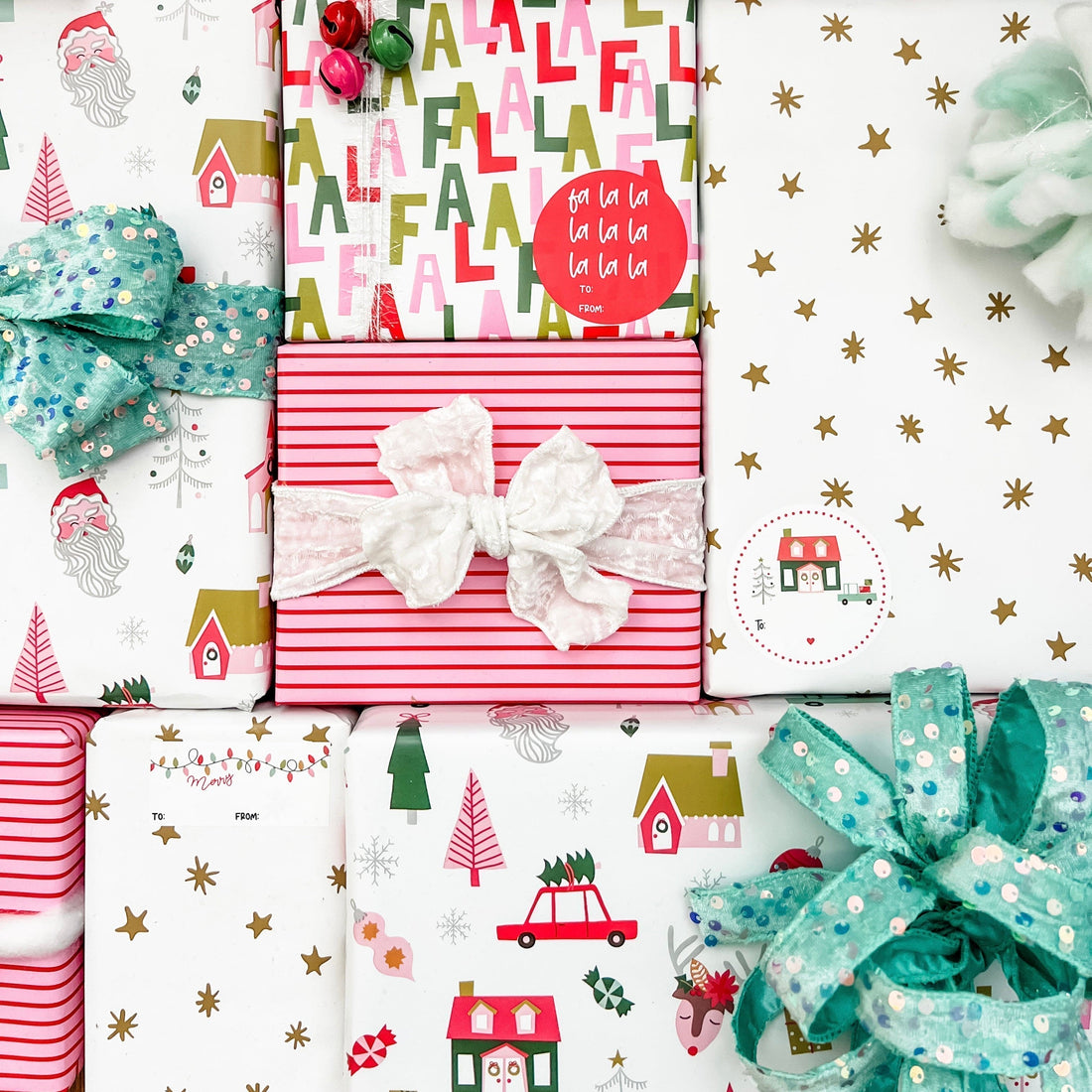 Red and pink striped wrapping paper with a red sequin ribbon and greenery on a matching background