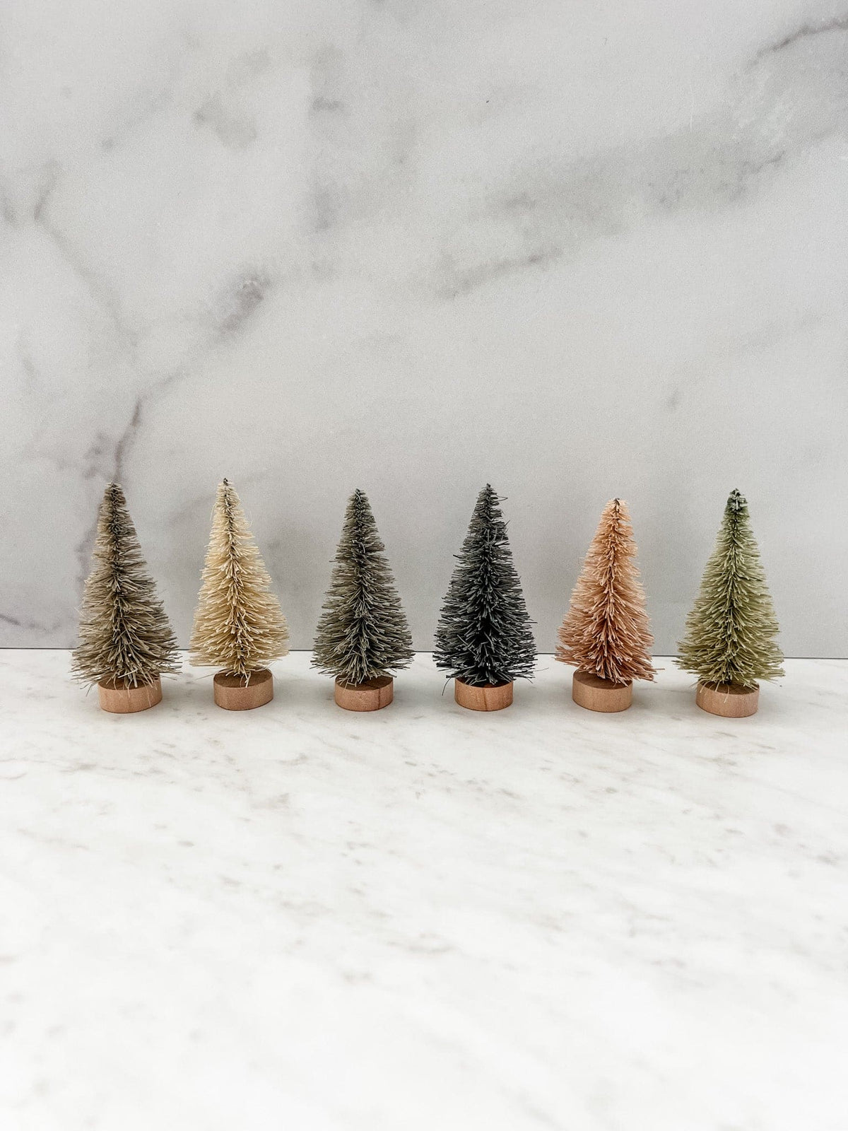 Set of 6 neutral bottle brush trees shown lined up to show the colors.
