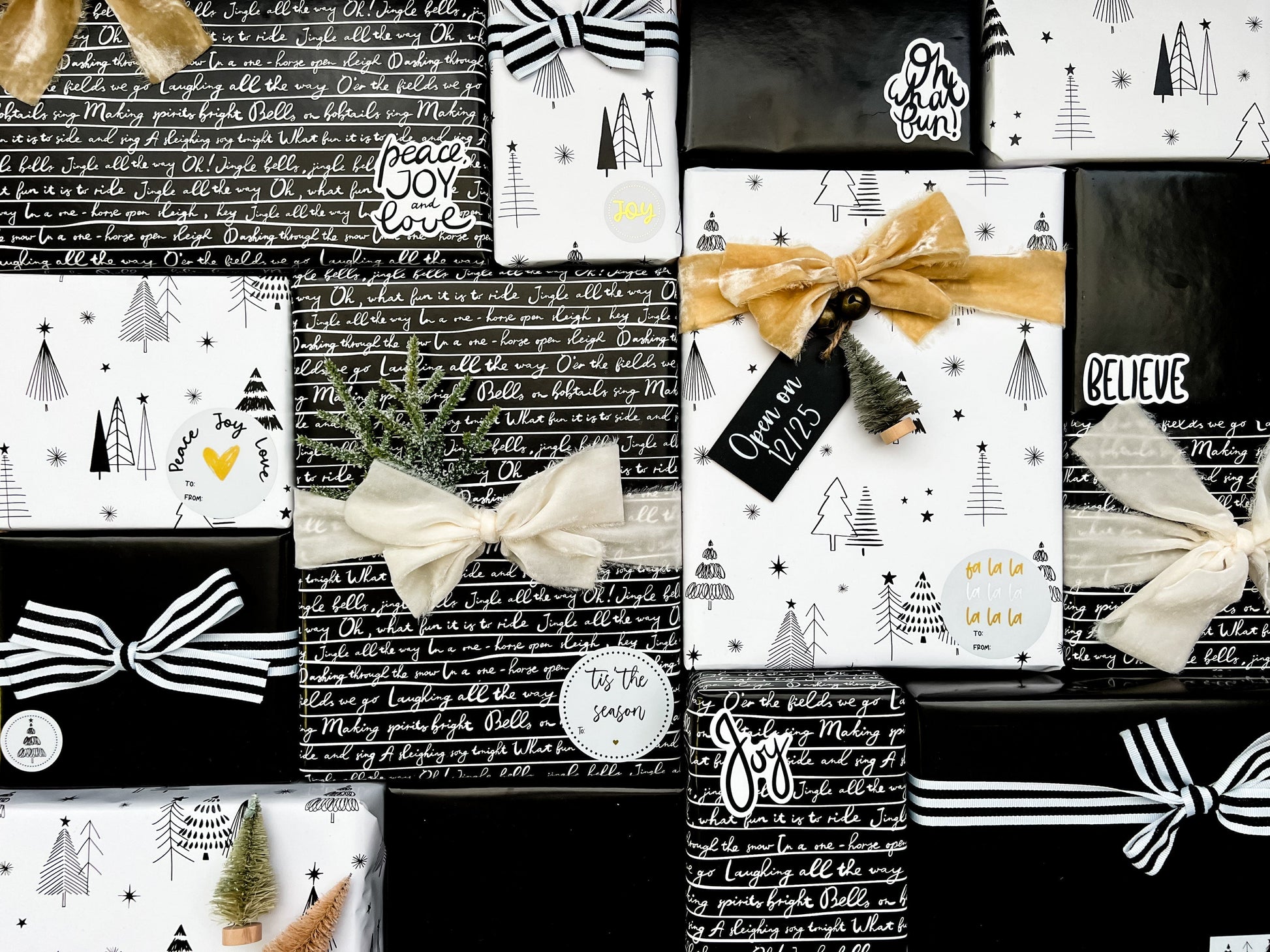 Collection of black, white, and gold gift wrap with festive designs and text.