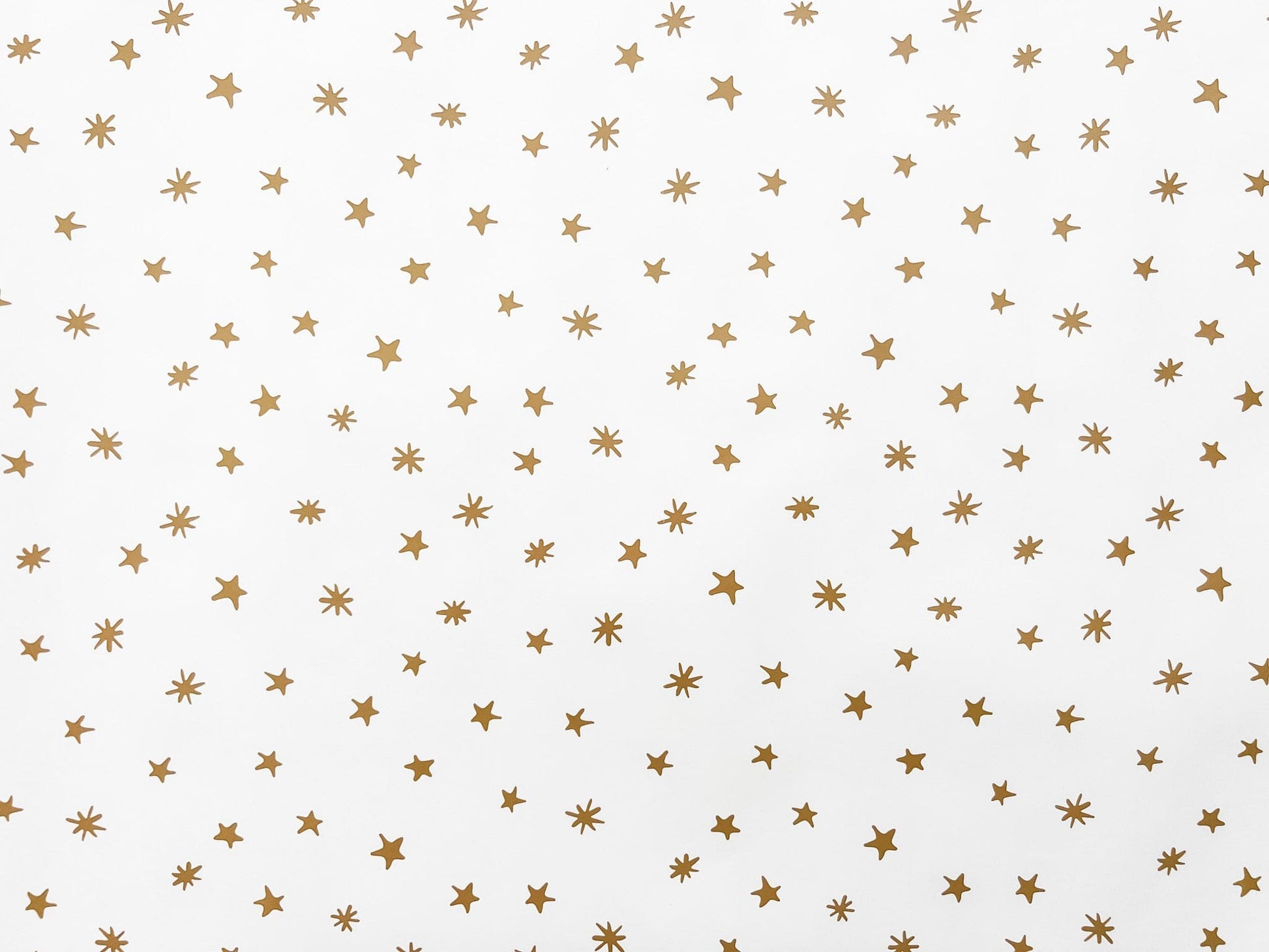 flat lay of white wrapping paper with gold stars