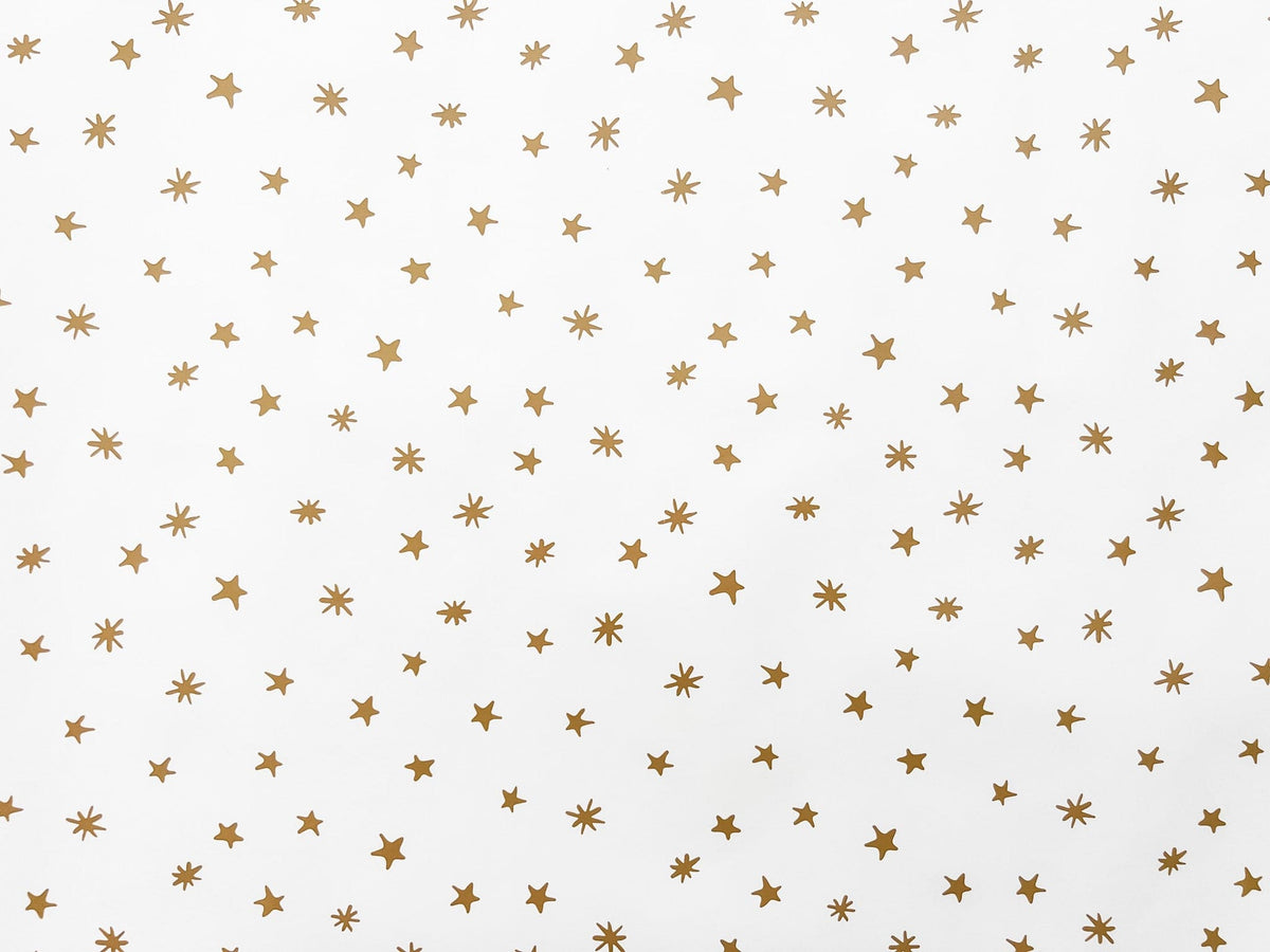 flat lay of white wrapping paper with gold stars
