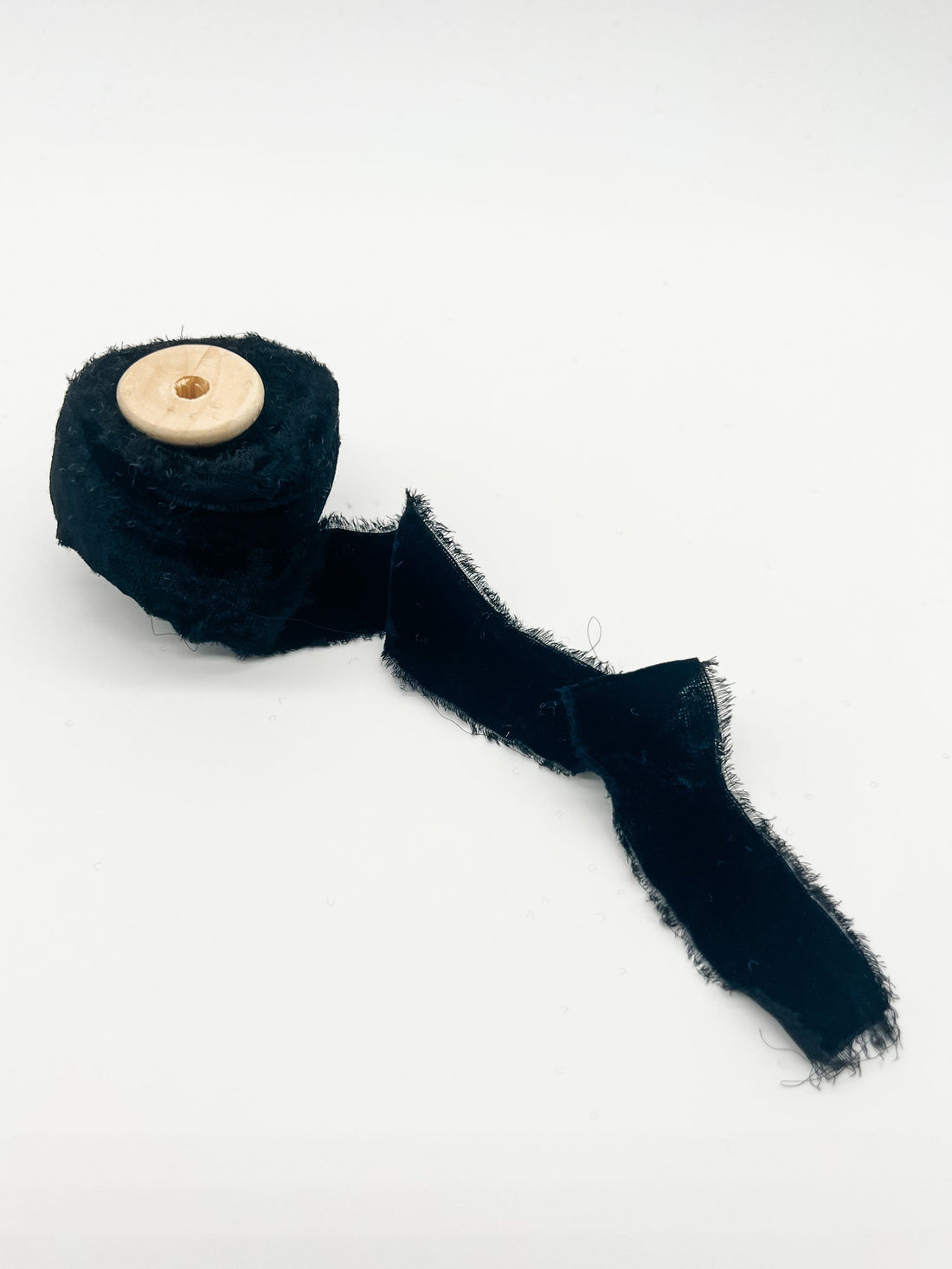 A collection of velvet ribbons in various colors including red, green, blue, pink, beige, black, and tan, with raw edges.