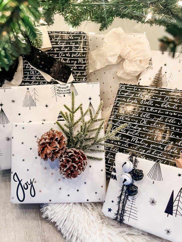 Gift boxes with Christmas-themed designs under a decorated tree